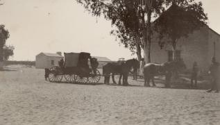 Horse drawn buggy in front of old church at Hermannnsburg.